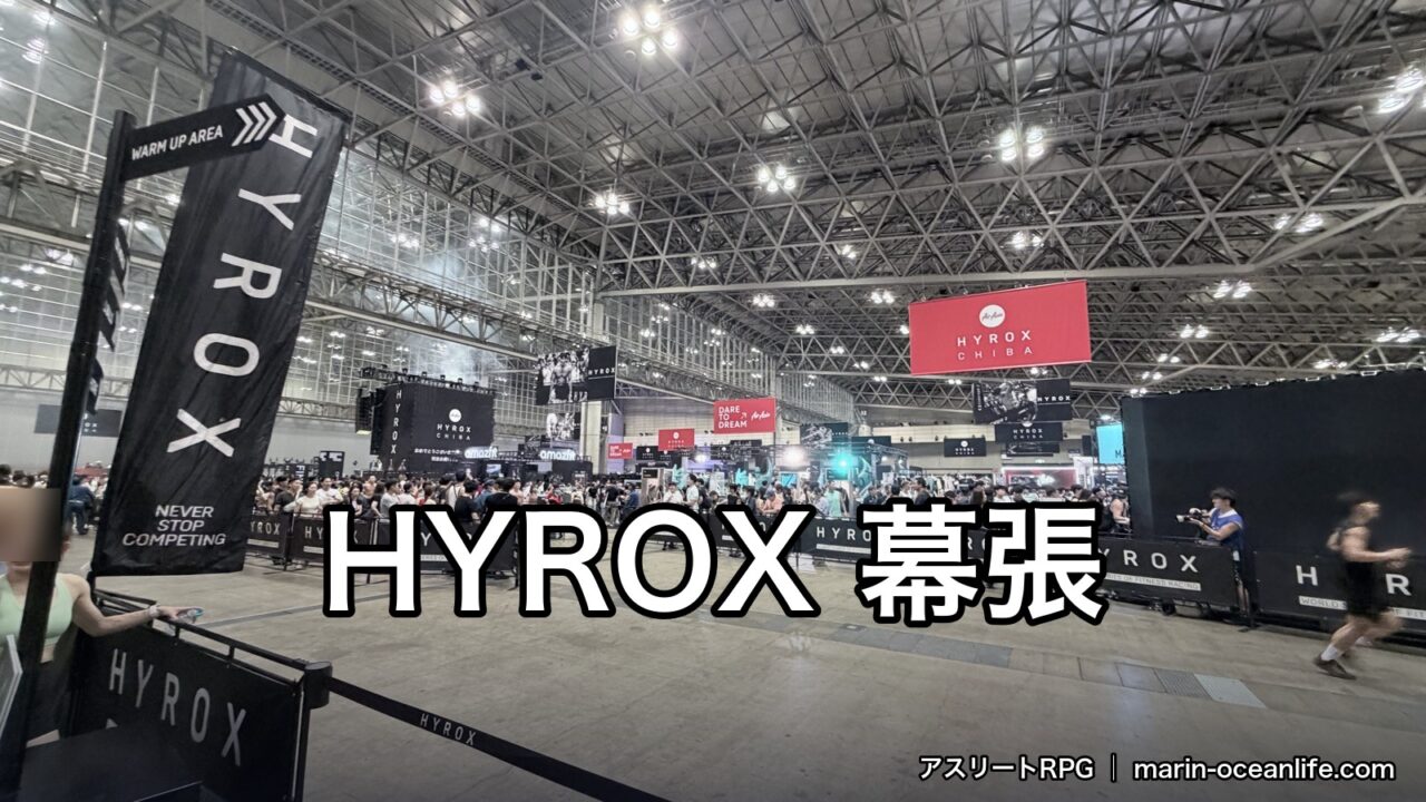 幕張メッセのハイロックス会場。HYROXの柵の向こうに出場者が集まり、「HYROX 幕張」の文字が入っている